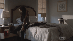 Instead of donning the uniform, Michonne sits on the edge of the bed, covers her face with her hand. It must be exhausting, the loss and hardship that never ends...it must be so hard to keep going, to not give up.