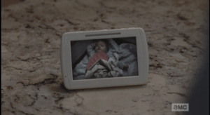 ...and Carol looks up at a tiny picture of a baby, most likely left there by the former residents of the home. Like Deanna, Michonne, and so many others, Carol is a mother who has lost her child in the apocalypse, and who has had to find the strength inside her to keep going, to keep living, while carrying this loss, this grief inside her.