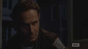 Glenn looks miserably up at Rick, who is sitting with him, watching him, listening.