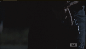 Rick goes and stands at the small pond near their homes.  Facing the water, he pulls out the contraband handgun from his waistband and holds it, crossing his hands, waiting.