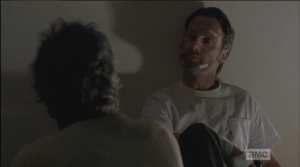 After taking the gun, Rick looks at Carol.