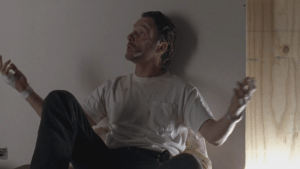 Rick opens his arms in mock surrender, announces, brattily,