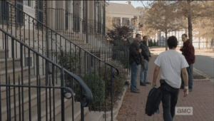 ...and begins to walk down the sidewalk, where Tobin and two other men stand. Tobin is wearing a rifle on his shoulder, a new development in Alexandria...the armory is being guarded, and it seems that Rick's quarters are under watch as well.