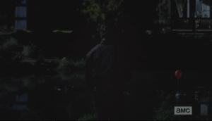 As Rick faces the pond, we see once again an image that Rick has noticed three times thus far in Episode 515...a helium-filled red balloon, tied to paper boat like a sail.  The breeze blows the balloon, gently propelling the paper boat in the water.