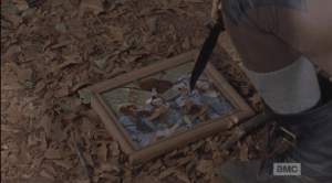 Rosita then kneels down, touches the shattered picture that Sasha had used as target practice a day or two earlier with the tip of her knife.