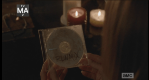 ...in the home of the Monroes, there seems to be a vigil being held for Aiden. Candles are lit, and we see Deanna's hands holding a cd of another one of Aiden's specialty