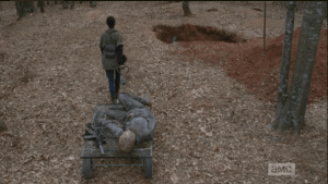 Sasha is doing the lonely work of cleaning up the walker bodies she rekilled up in the tower. She loads another one on her cart and pulls it towards a deep pit that has been dug for walker burial.