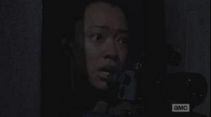 ...but as Sasha tries to peer through the scope, and focus, we see she is shaking, distressed, near tears.