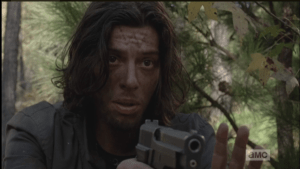The young man motions Morgan back, while pointing the gun at Morgan.