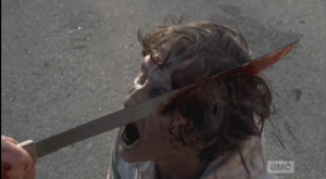 Aaron brings his machete down on a walker's head...