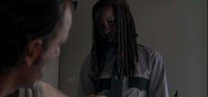 Michonne tosses the constable's jacket on the bed, fixes Rick with a look.