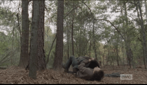 Nicholas gets some good shots in on Glenn, and does the dick maneuver of jabbing a finger or thumb into Glenn's bullet wound, causing Glenn to cry out in pain. Glenn tackles Nicholas to the ground...