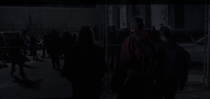 We see the Wolfboys walking Red Poncho Guy, whose hands are tied behind his back, up to the gates of the distribution center, where the walkers snarl and grab at the fence.