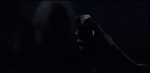 We see a hand press a button on a remote, and suddenly, lights flash inside the open truck trailers, and a happy, soothing, singsongy song plays loudly in the fenced area. The walkers turn toward the lights and noise...
