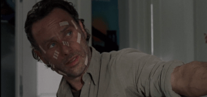 Rick holds out the gun for Michonne to take. Michonne makes no move to take the gun.