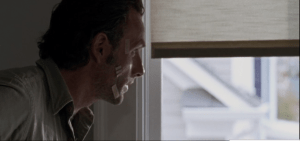 Alarmed, Rick grabs his jacket, and rushes out of the room.
