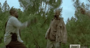Morgan, squaring off with a walker, trusty wooden staff in hand. We see an outstretched hand cocking a pistol, ready to fire upon the walker, but Morgan's like,