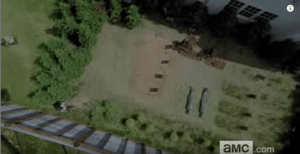 We see an aerial view of Alexandria's makeshift cemetery, with fresh graves being dug for two more bodies. Looks like Alexandria's gonna need a bigger graveyard...