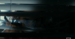 Nick silently motions his mother, sister back and moves quietly towards the front door as the dog continues to bark. Nick peers through the slats of the vertical blinds and sees...