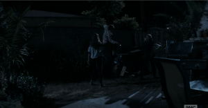 Nick, Madison and Alicia slip out the open back door and begin to climb the fence to their neighbor's home as the dog continues to bark frantically inside the house.