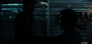 Chris (looking through the spaces in the window barricade):