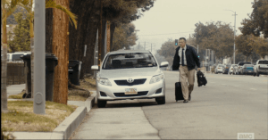 ...Patrick Chan returning home, pulling his suitcase from his car, and heading towards his house, where his reanimated wife, Su Su, wanders the back yard labyrinth.