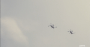 As military helicopters fly overhead...