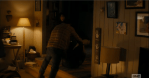 Chris has rushed forward and managed to drag his dad back towards the steps, and Travis is able to bend his knees up and press his feet against Dawson B.'s belly...