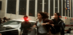 Liza, Chris, and Travis break into a full run for their safety as everything around them begins to devolve into violence and chaos.