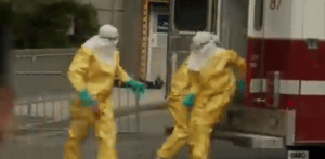 Liza sees the EMT's file out of the ambulance with head-to-toe hazmat suits to collect the body.