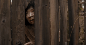 The sounds of Travis's shovel spearing the earth get Su Su B.'s undead attention, and she comes to the opening in the fence...surely, she has been wandering the labyrinth all night, if not peering and reaching through the fence towards the house of the living.