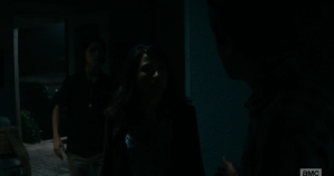 Travis hears a noise, turns to see Liza and Chris have followed him inside.