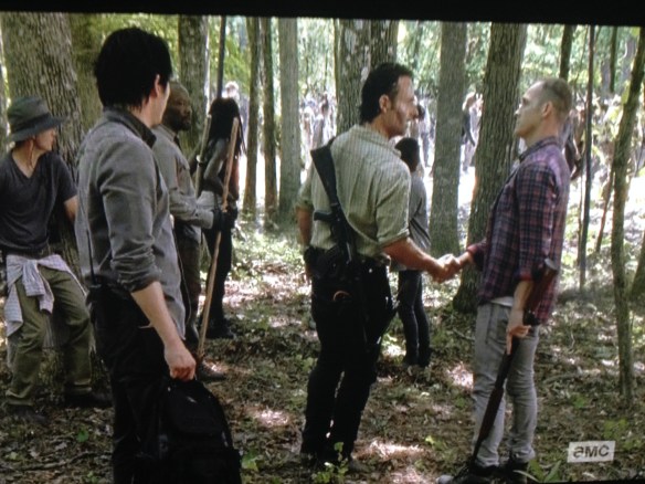 Carter holds out a hand, and Rick takes it. The men shake, making peace.