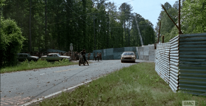 As the mass approaches, Rick, Morgan, and MIchonne begin firing well-timed, well-placed flares to distract the walkers' attention from charging full-forward into the wall, and lead them around the bend.