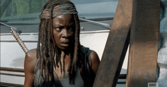 Michonne fires a flare, then edges closer, bracing herself, peering through the corner...