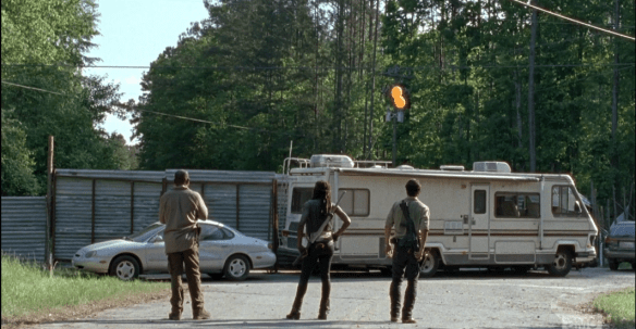 In the next scene, we see Rick, Michonne, and Morgan running ahead of the dreaded walker parade. Rick radios Glenn, checks in. It seems Glenn and the others are right on time, ahead of the horde, at the tractor store. As they regard the barricade they set up, before, RV and car parked in front of metal gates, Rick says, 